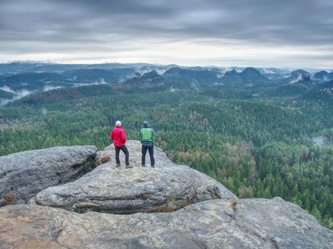 Man stay for a moment for overlooking the misty landscape below  view point. Trail at the edge of a cliff 