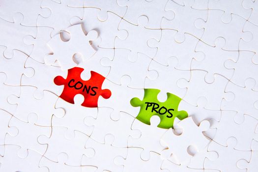 The words pros and cons on the missing puzzle pieces. Business concept