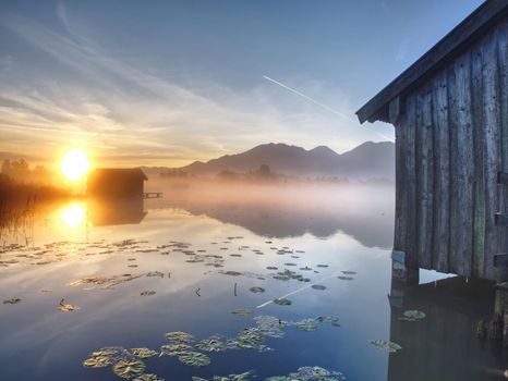 Romantic mountain lake view. The mountain lake with dock and boat house