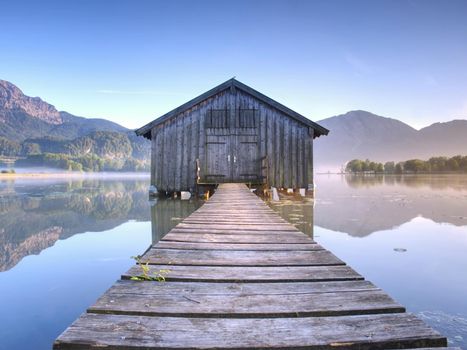 Wooden boat house.  Silent mountain lake and Boat shed
