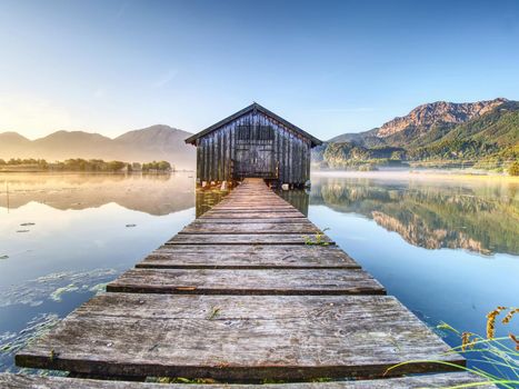 Beautiful mmorning at lake with traditional wooden boat house. Shore of famous mountain ake Nationalpark, Germany 