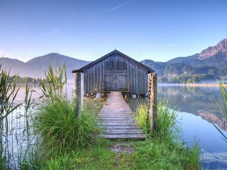 Traditional wooden boats old house at the alpine mountain lake. 