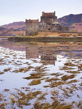 Eilean Donan Castle with a stone bridge above the water,  Scotland,  It was destroyed during the Jacobite rebellions in the early 18th century, and rebuilt