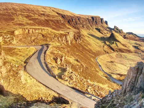 Spring view of Quiraing mountains with blue sky, Isle of Skye. Sharp rocky mountains above vallley. Sunny winter midday.