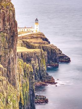 Neist Point Lighthouse, famous photographers location on the Isle of Skye in Scotland.  Melancholy morning after rainy night.