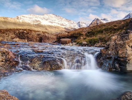 Multiple waterfalls, seemingly vibrant blue and  green in color, with cold swimmable pools. Popolar trek at Glenbrittle, Isle of Skye, Scotlland