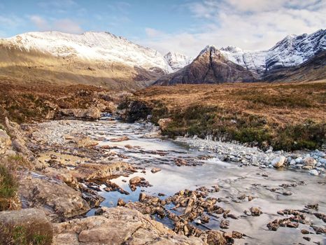 Waterfall between sharp exposed rocks, the Fairy pools on the Isle of Skye, Scotland. Trek by popular footpath by crystal clear blue pools on the River Brittle