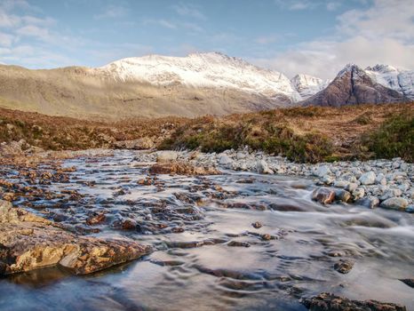 Multiple waterfalls, seemingly vibrant blue and  green in color, with cold swimmable pools. Popolar trek at Glenbrittle, Isle of Skye, Scotlland