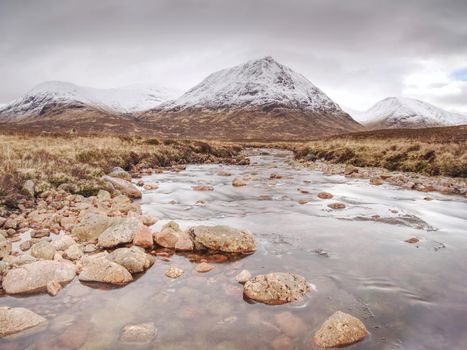 Buachaille Etive Mor alongside the river Coupall near Glencoe in the Scottish highlands.Sunny winter day.