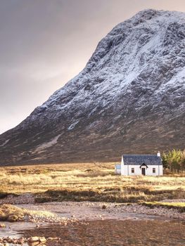 Climbers base, white house at Glencoe mountain, Scottish Highlands, Scotland. Sunny spring day, February 2017.