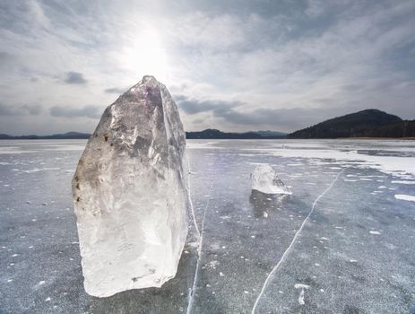 Winter view of the frozen  sea to the opposite bank.  The sun in ice colorful glare  