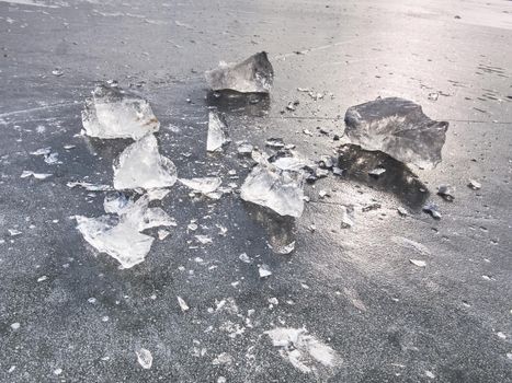 Shining shards of broken ice. Abstract still life of ice floes on lavel of frozen lake.