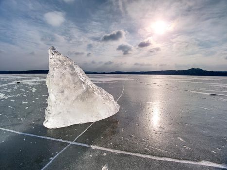 Winter view of the frozen  sea to the opposite bank.  The sun in ice colorful glare  