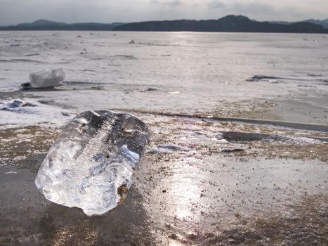 Arctic cold landscape of icy lake at sunset with cracks and patterns on the ice. Winter landscape 