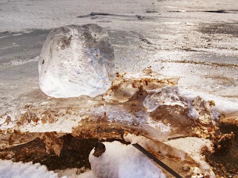 Beautiful epic ice crystal in the frozen bay.  Sun rays reflection in cracks, backlight  of the setting sun.