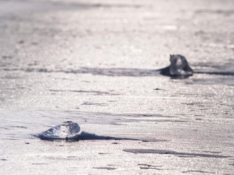 Sun shining through the transparent  ice floe. Water under transparent ice cover in silent bay. 