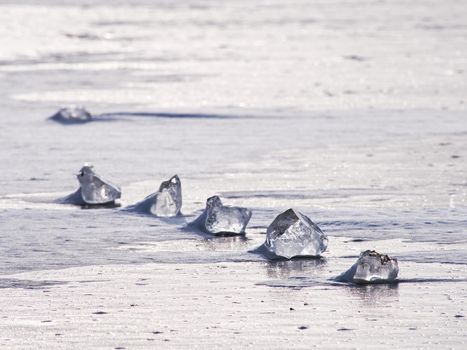 Transparent ice block on  frozen sea surface. Amazing Sun  reflection in scratches and cracks. Winter season