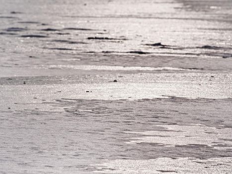 Melting ice crystals and icebergs. The beach covered by thick ice in winter time.