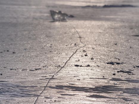 Melting ice crystals and icebergs. The beach covered by thick ice in winter time.