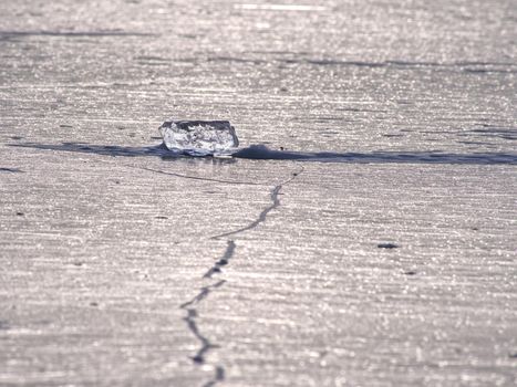 Shards of cracked ice jut out on the frozen lake. The light phenomenon occurs around a very specific time of year