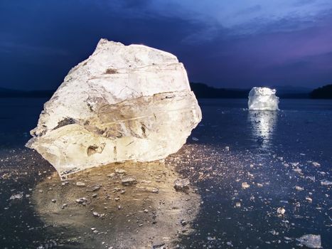 Blocks of shining ice and snow on the shore. The floes and crushed ice  during the evening and dark  hours when the ice at sea breaks up.