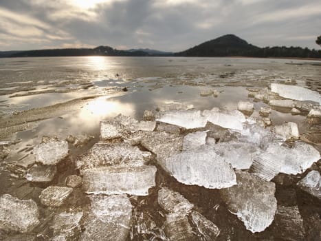 Broken floes and  iceberg. A large ice piece on freshwater ice that has broken off a glacier or an ice shelf. Reflection in ice