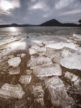 Ice fragments on the lake. Flat surface of  frozen lake. Kra, ice on the water surface. Season of the early spring.