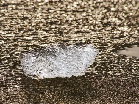 Detail of  frozen icy sheet. Ice cracks forming surface,  floes flowing on cold river water during winter.