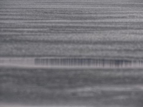 Ice and icy cracks on surface of the frozen lake. Abstract blurry focus. Texture of glacier ice. Natural texture of the ice