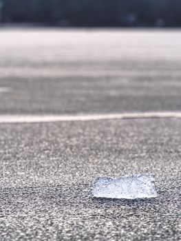 Blue ice floe on dark grey or black ice of sand beach. Strong wind breaks   natural icebergs on offshore. Winter season landscape 