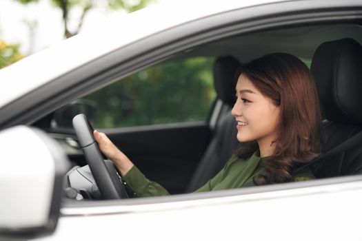 Beautiful woman driver smiling to you from her car