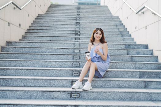 Young woman sit and using smart phone at outdoor stair,  Lifestyle of modern female.