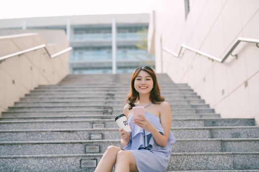 Young woman sit and using smart phone at outdoor stair,  Lifestyle of modern female.