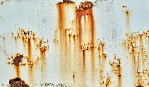 Patches of rust and rust staining are mixed with cracked and peeling paint on a metal surface