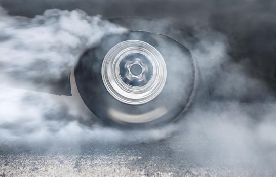 Drag racing car burns rubber off its tires in preparation for the race
