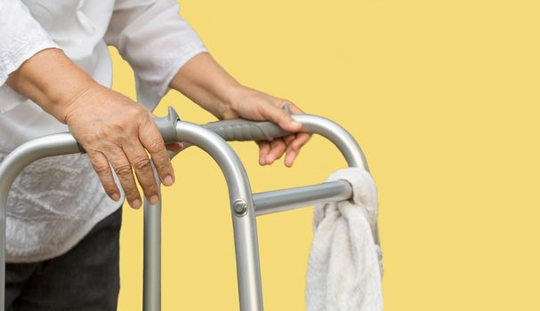 senior woman using a walker cross street with caregiver