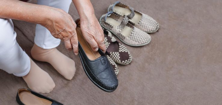 Elderly woman putting on shoes