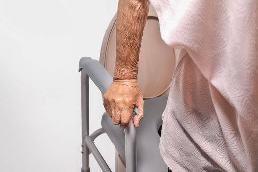 Elderly woman using mobile toilet seat chair