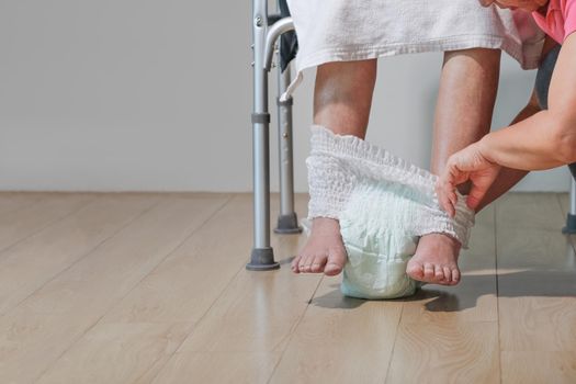 elderly woman changing diaper with caregiver