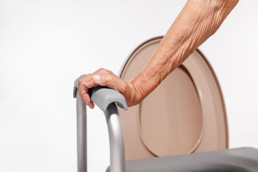 Elderly woman using mobile toilet seat chair