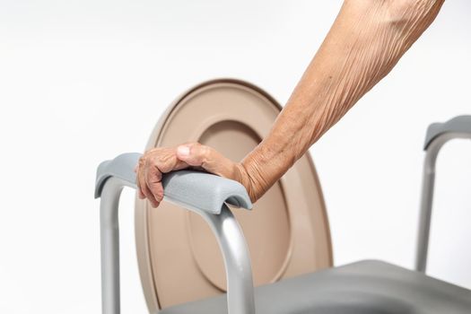 Elderly woman using mobile toilet seat chair