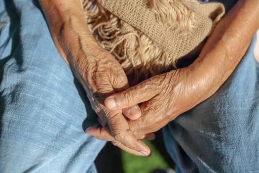 Elderly hands on a wheelchair.