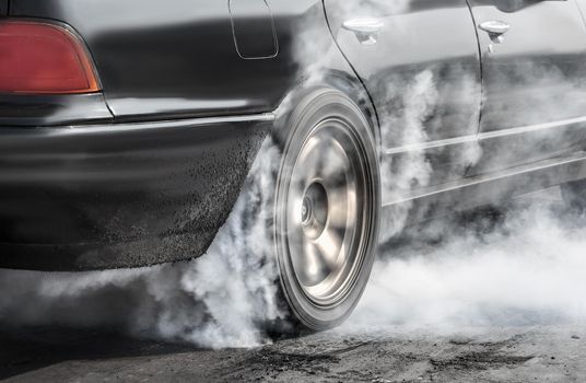 Drag racing car burns rubber off its tires in preparation for the race