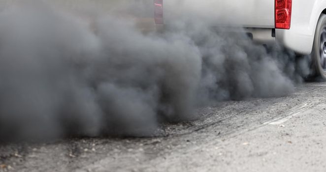 air pollution crisis in city from diesel vehicle exhaust pipe on road
