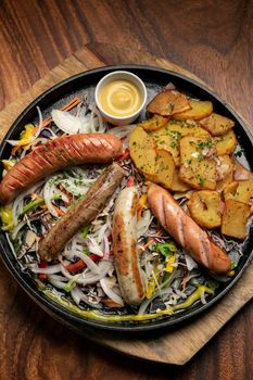 mixed german traditional organic sausage and potato meal platter including Nurenberger, Lamb and Pork with salad and mustard