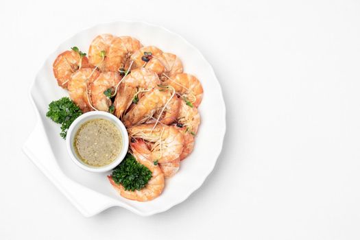 fresh boiled prawns with zesty citrus dipping sauce on white background