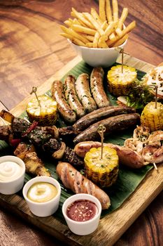 organic mixed grill barbecue meat platter rustic set meal with sausages, skewers, side dishes and sauces