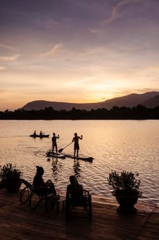 kampot river view in cambodia with SUP stand up paddle boarding tourists at sunset