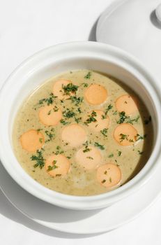 German traditional KARTOFFELSUPPE potato and sausage soup on white tabel background