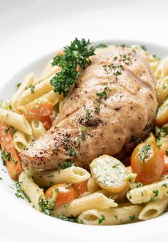 fried chicken breast with penne and saute vegetables pasta dish on wood table background